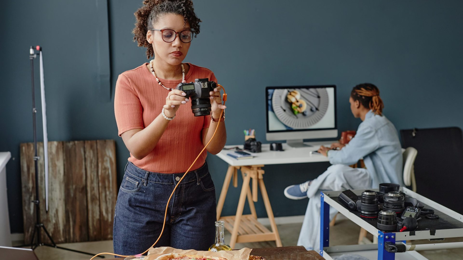 young-black-woman-photographing-pizza-in-professio-2026-01-09-12-00-27-utc