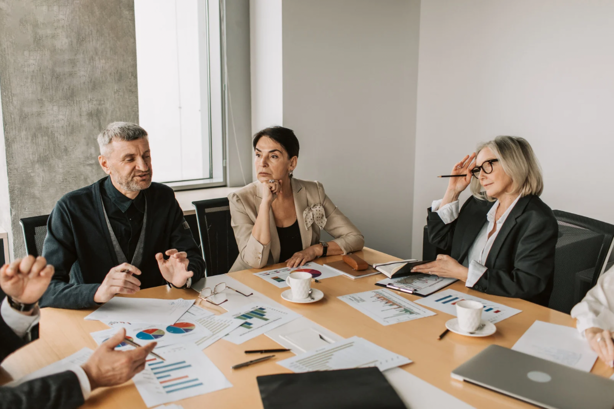 A group of professionals in a boardroom discussing market data and brand strategy to define their competitive positioning.