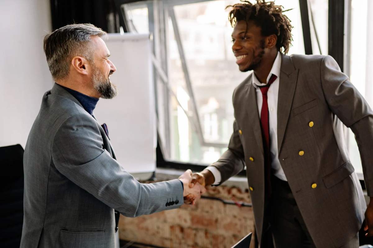 Image of two professionals shaking hands, representing trust and long‑term relationships built through consistent brand behavior.
