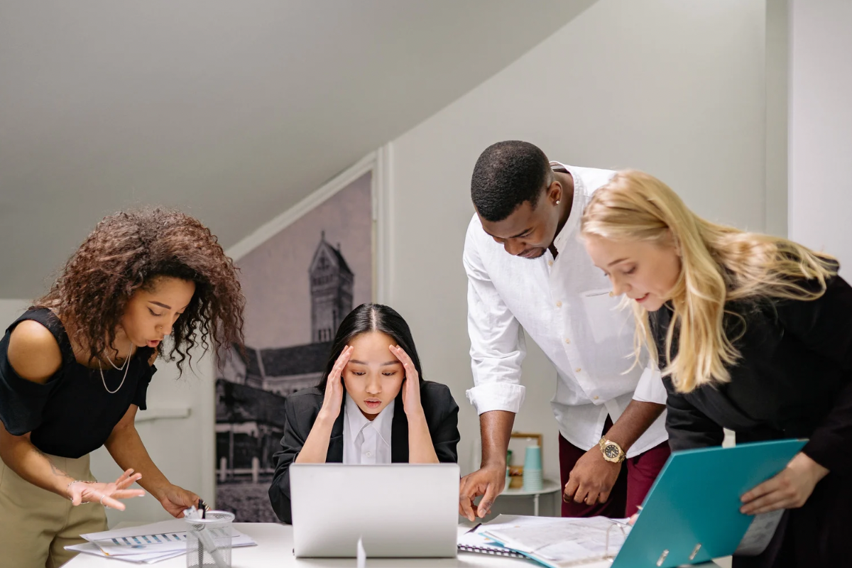 Stressed marketing team looking at a laptop, representing the frustration of skyrocketing customer acquisition costs and ad fatigue.