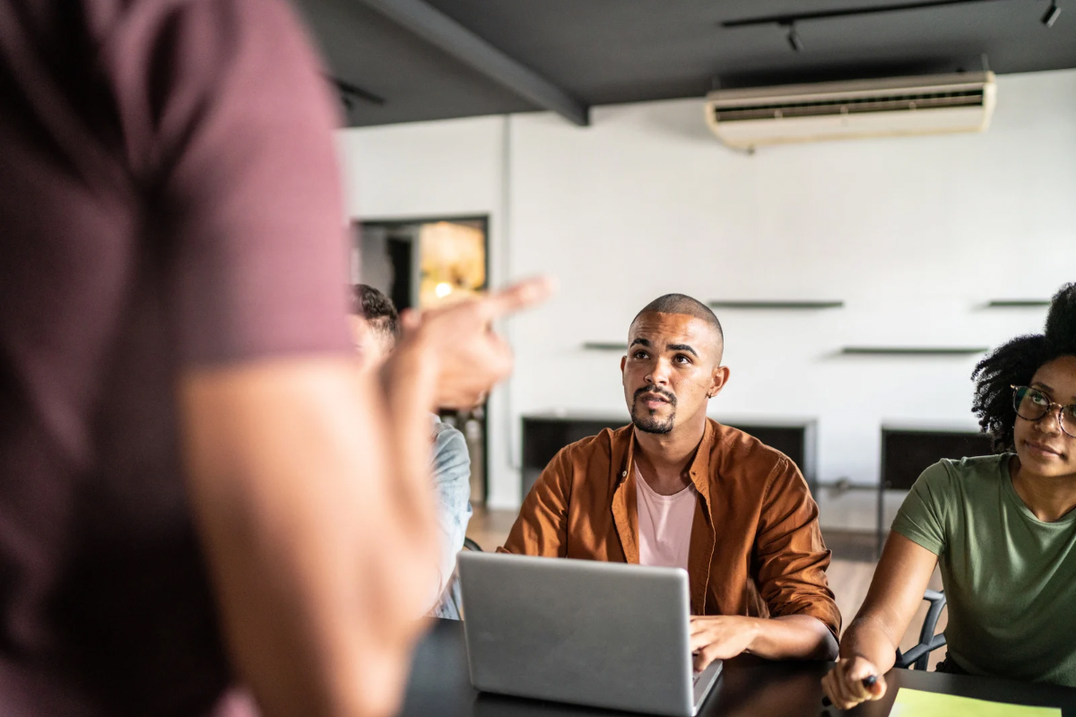 A diverse team having a discussion in a modern office, representing the act of listening to customer feedback and sales calls.