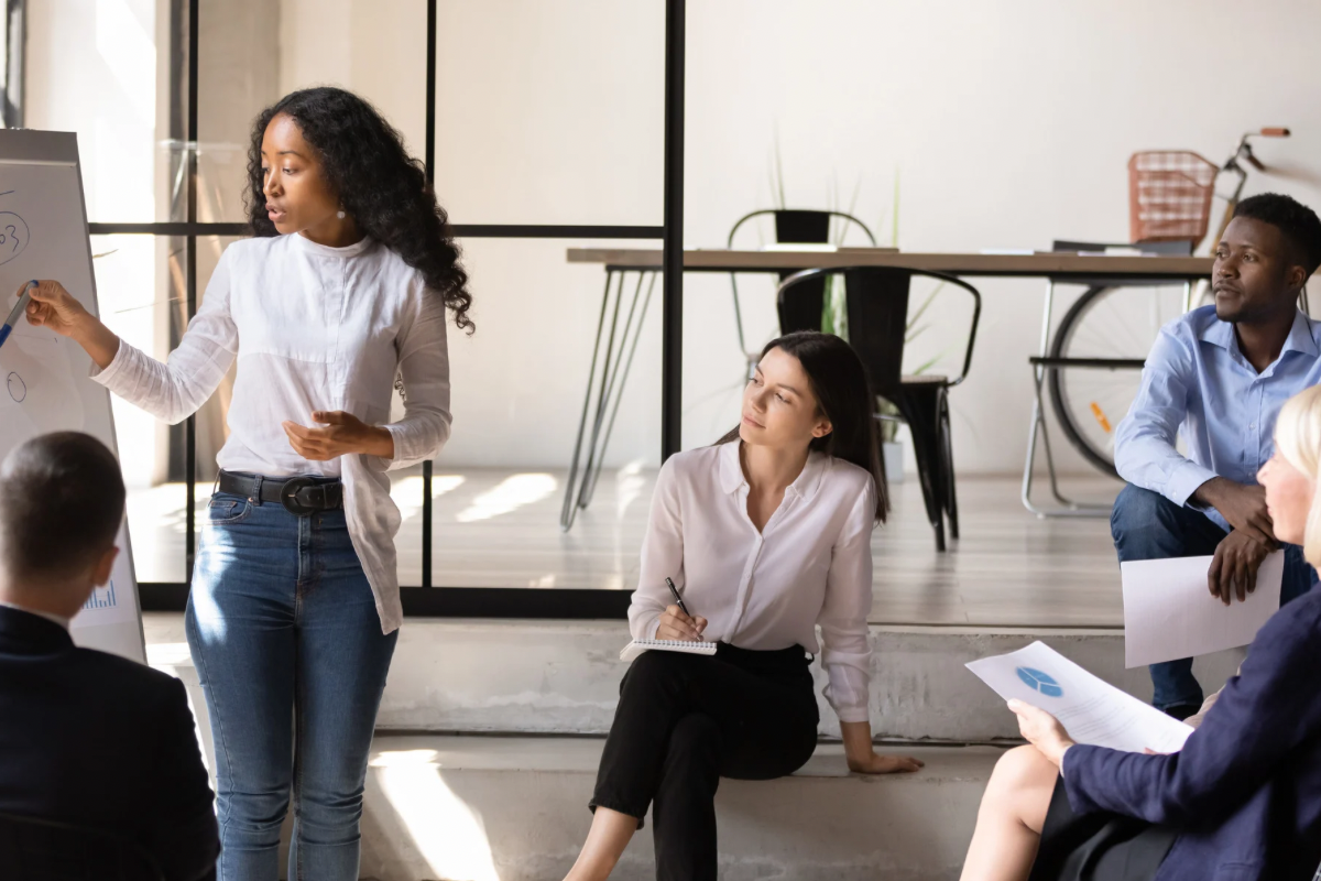 A professional woman giving a presentation to colleagues about shifting audience preferences toward authentic brand identities.