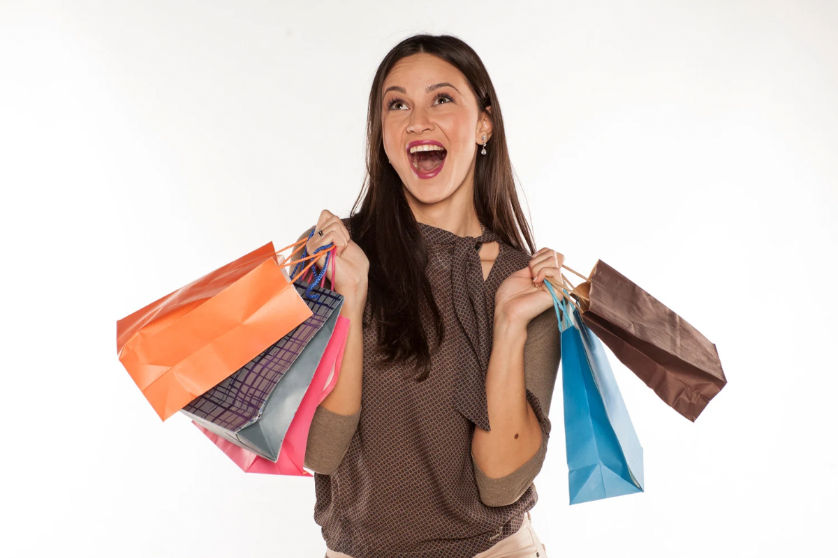 Happy shopper holding multiple shopping bags representing emotionally connected customers and brand storytelling impact