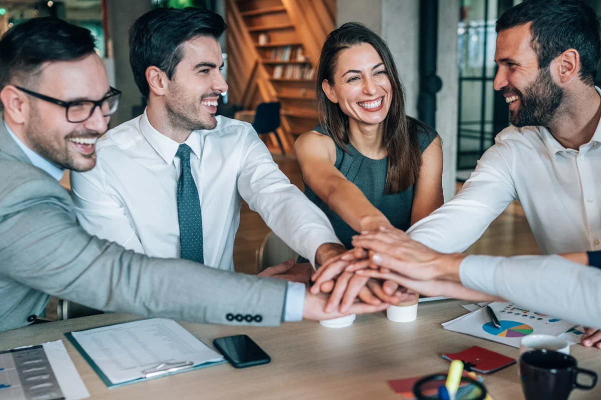 A business team joining hands, symbolizing the internal strength and unity created by a shared company purpose.