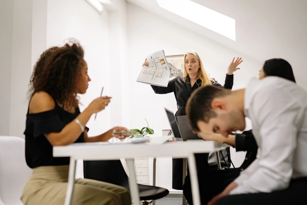 Frustrated business professionals experiencing conflict during a tense office meeting.